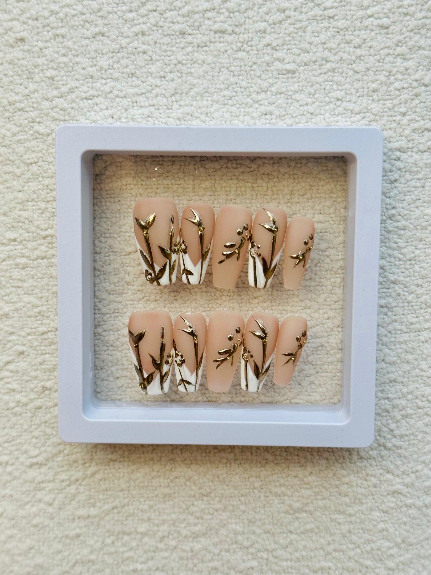 Ongles français à coller faits main, motif fleurs dorées | Blanc élégant avec des touches florales dorées