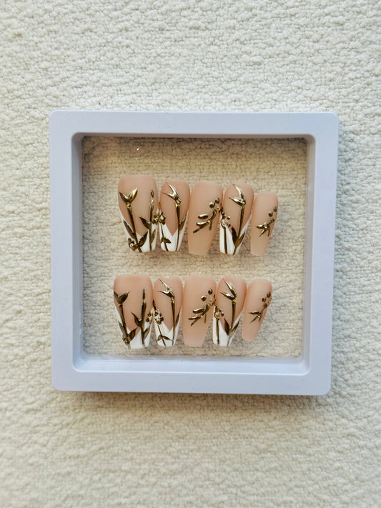 Ongles français à coller faits main, motif fleurs dorées | Blanc élégant avec des touches florales dorées